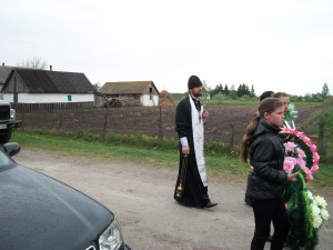 The priest leading the way to the cemetery